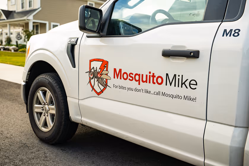 White truck door with Mosquito Mike company logo and slogan 'For bites you don't like...call Mosquito Mike!'