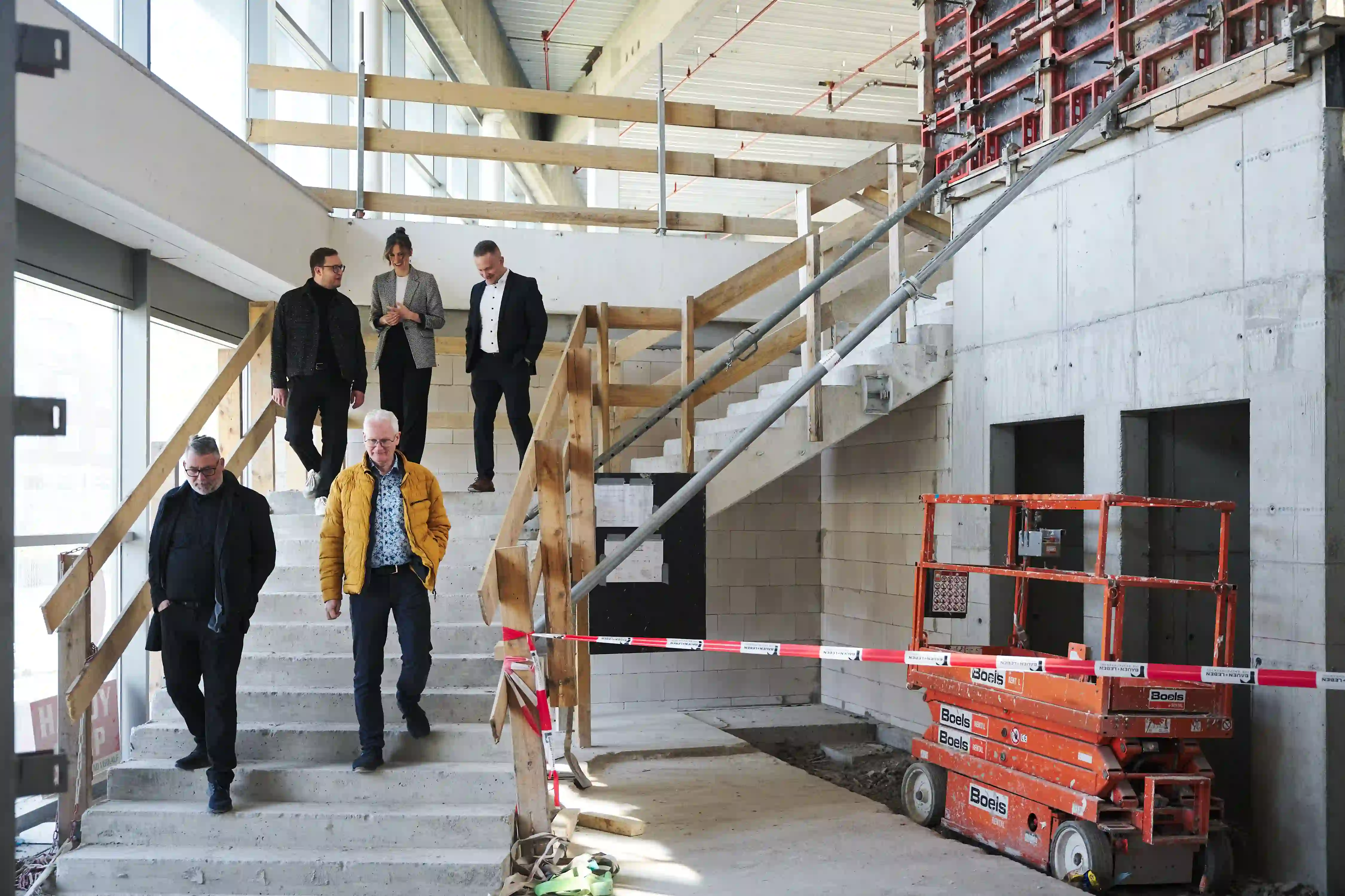 Fünf Personen stehen auf einer Treppe im Rohbau des Einkaufzentrum "Minister Stein"