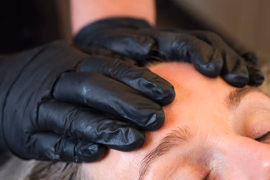 Vrouw ontvangt een professionele gezichtsbehandeling bij Essenzi Huidstudio