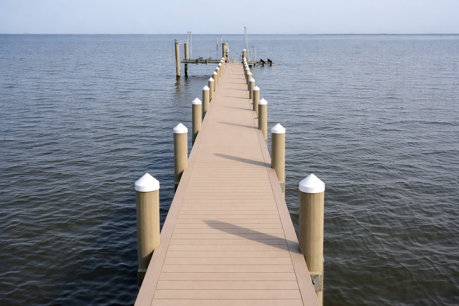 Atlantic Industries Marine Division dock construction with composite decking and timber pilings extending into open water at a marina.