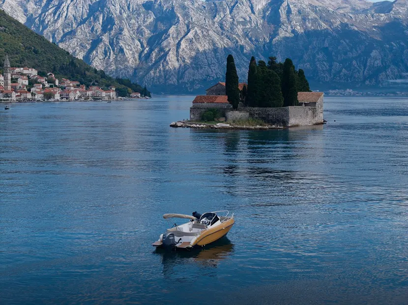 Private boat near Our Lady of the Rocks in Perast Montenegro on calm sea