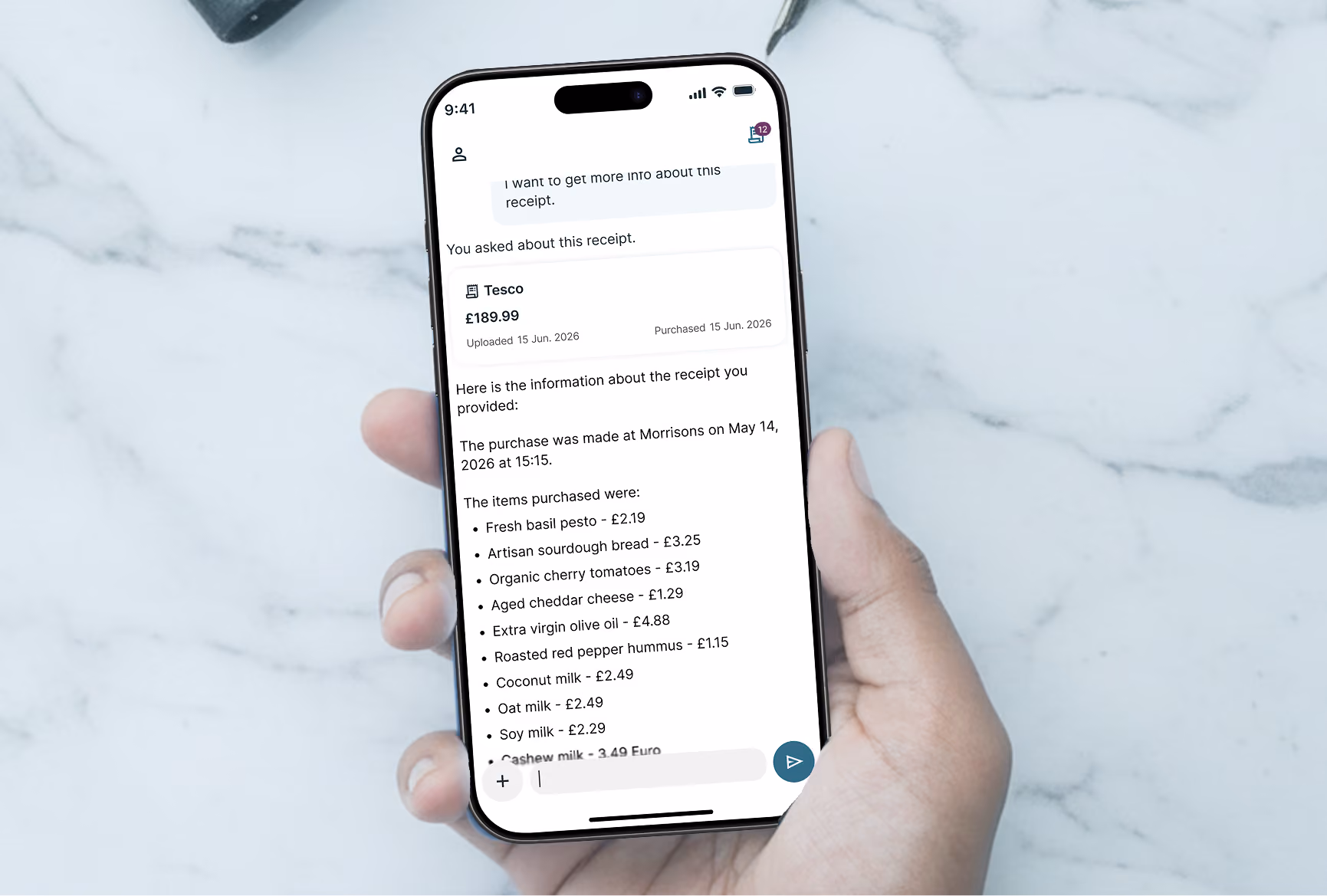 Hand holding phone showing a digital receipt with itemized grocery purchases and prices.