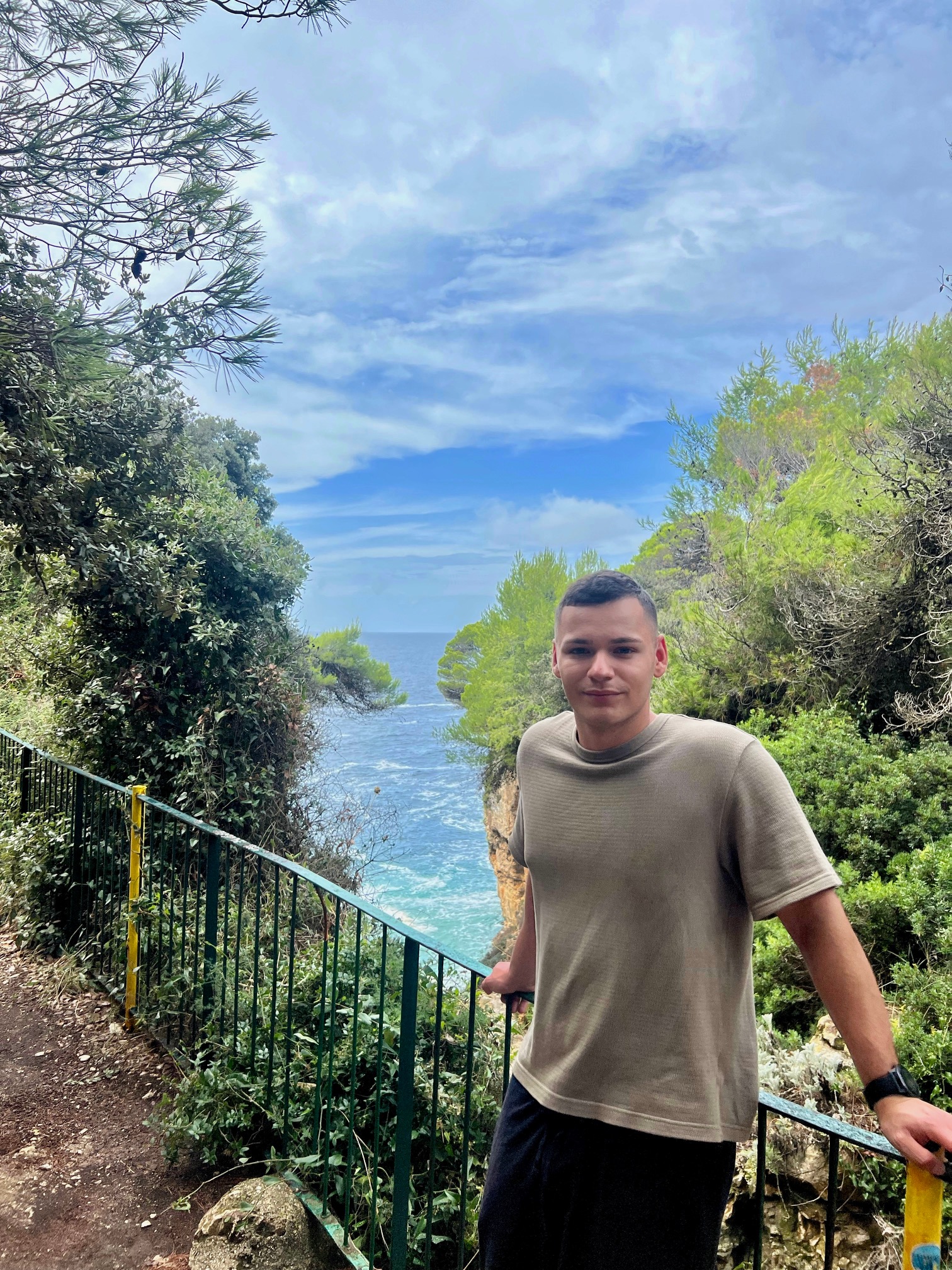 Hubert Adamkowski - Junior UI/UX Designer posing against a cold sea background