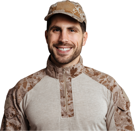 Smiling soldier wearing a tan and brown digital camouflage uniform and cap against a black background.