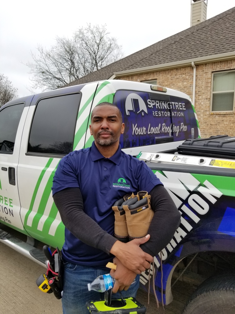 Springtree Restoration team member beside a branded company vehicle.