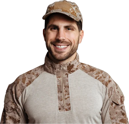 Smiling soldier wearing a tan and brown digital camouflage uniform and cap against a black background.