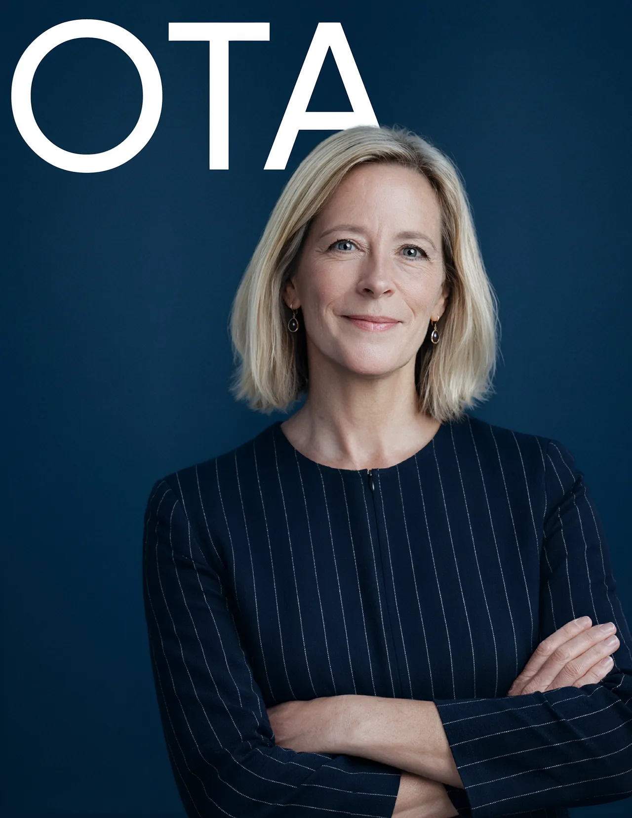 Confident woman with short blonde hair wearing a pinstriped navy blazer, standing with arms crossed against a dark blue background with large white letters 'OTA'.