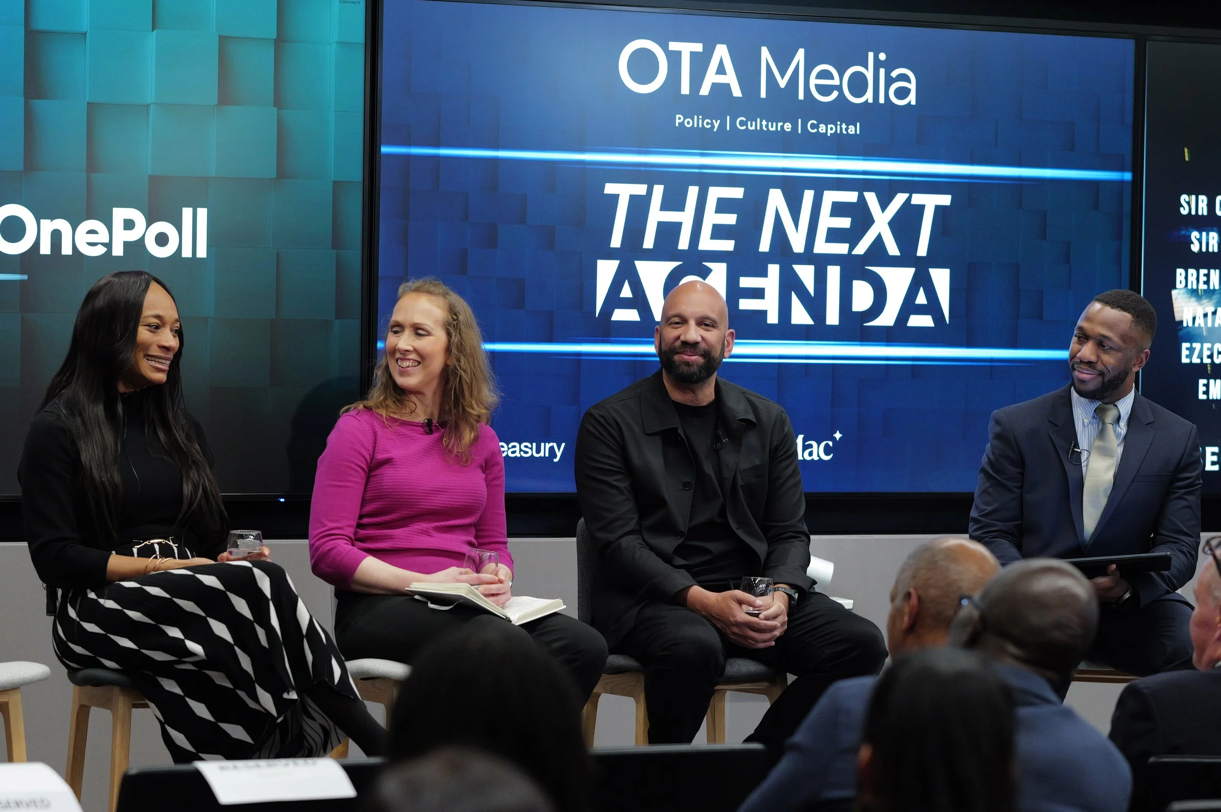Four panelists seated on stools smiling and talking during a discussion event with a screen behind them displaying 'OTA Media The Next Agenda'.