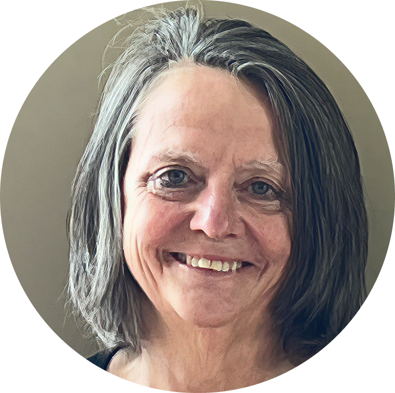 The owner a smiling middle-aged woman with shoulder-length gray hair against a plain background.