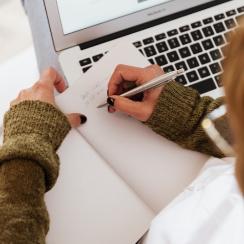 Woman taking notes at her laptop
