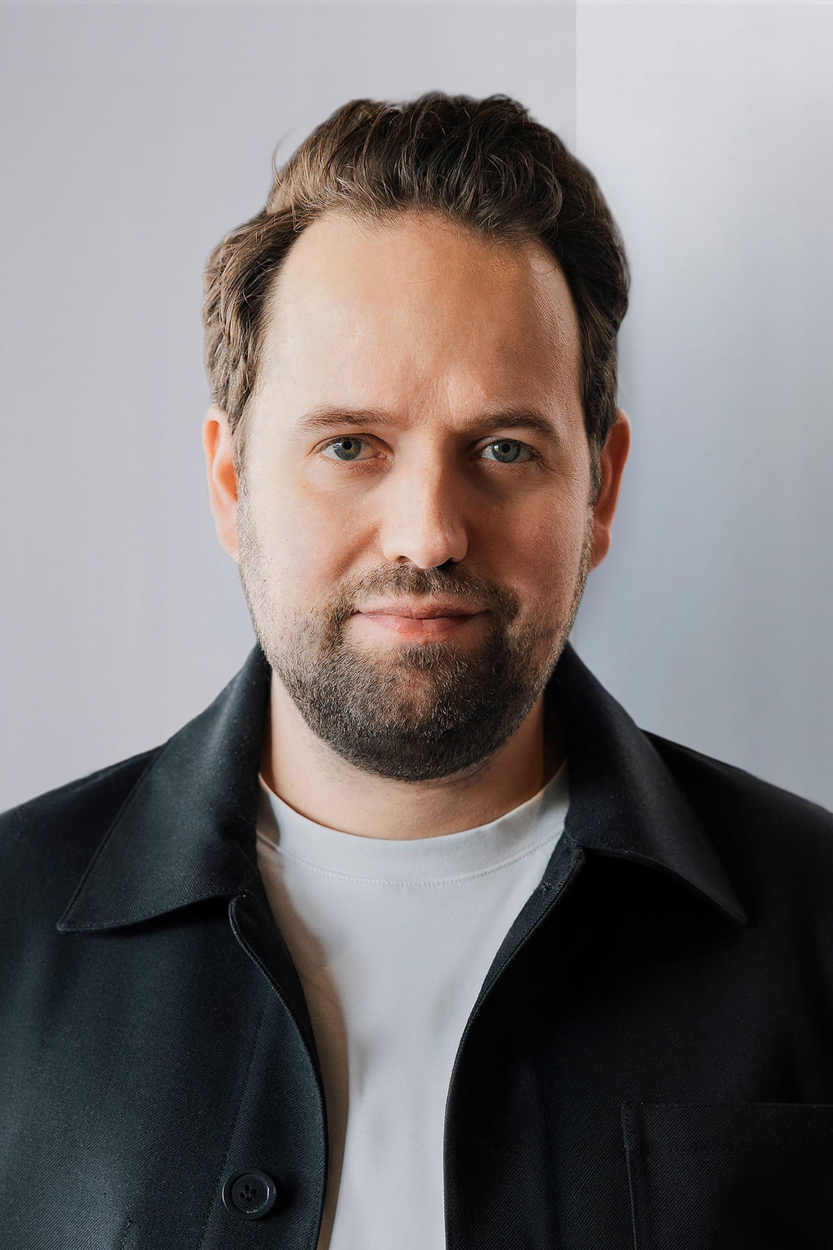 Portrait of a man in front of a grey wall