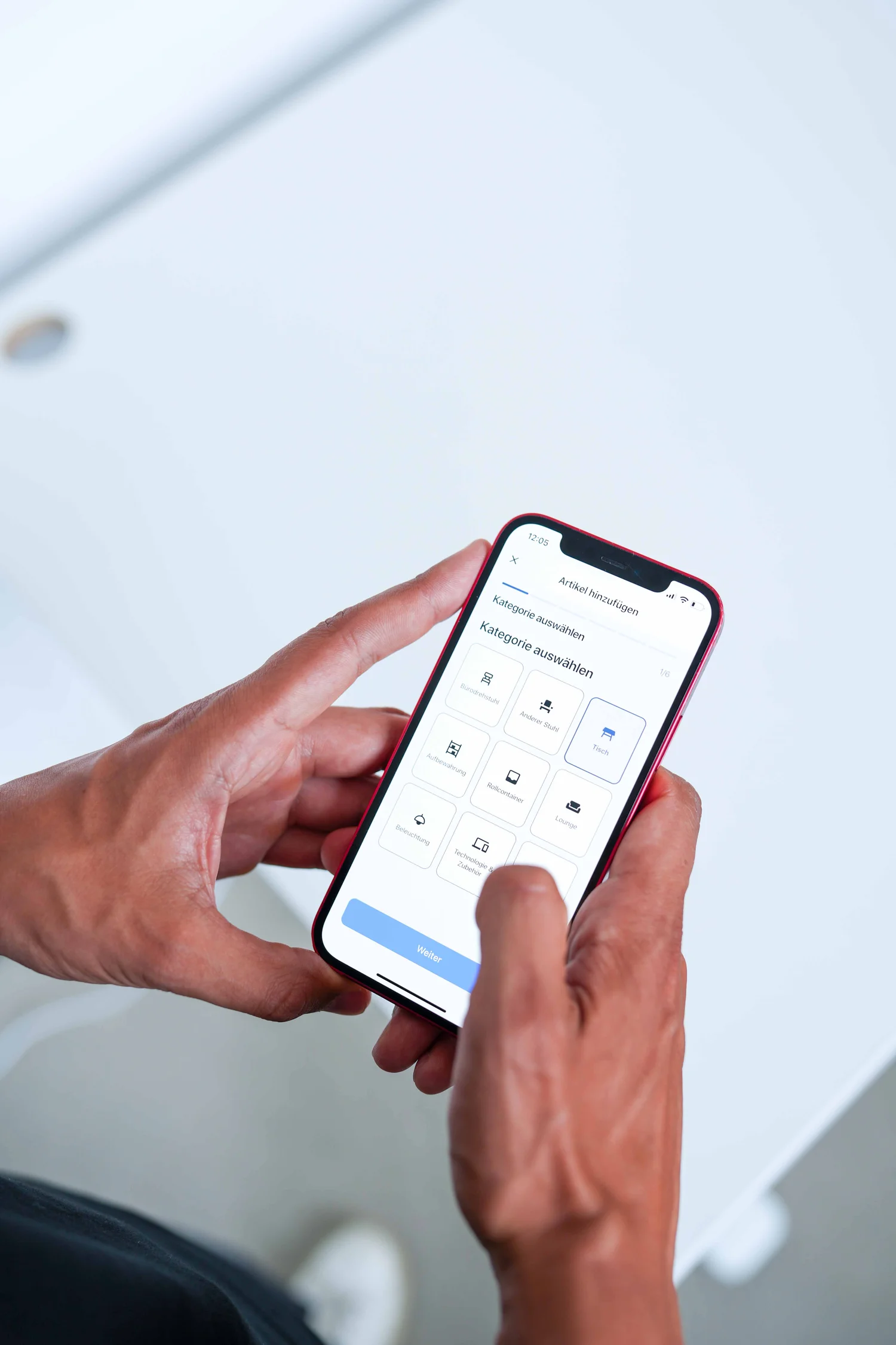Person using a smartphone app to select a category from options like office chair, other chair, table, and storage.
