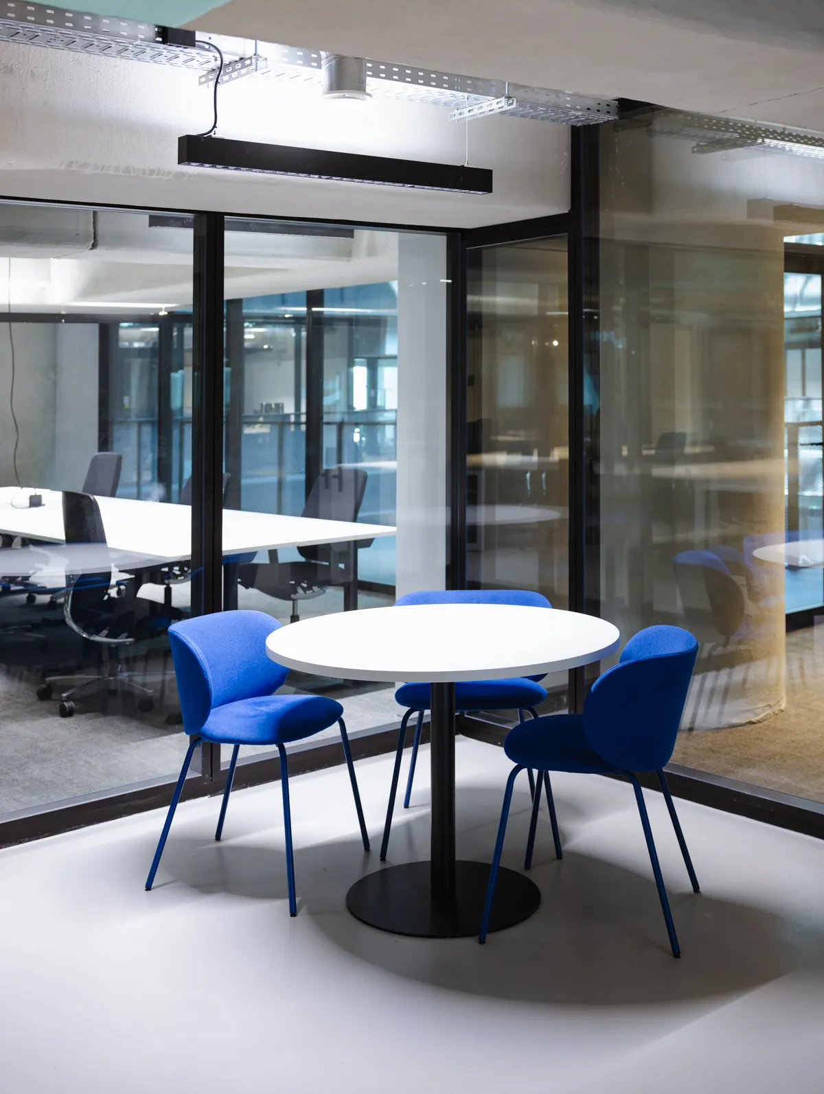 Modernes Büro mit höhenverstellbaren Schreibtischen und blauen Bürostühlen