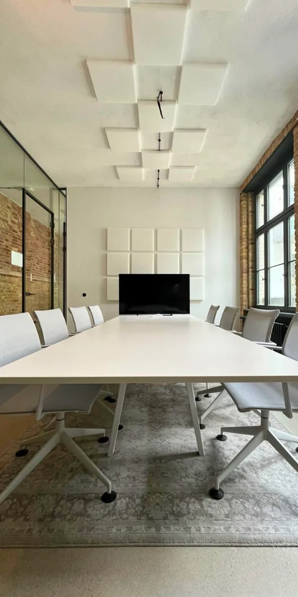 Minimalistischer Besprechungsraum mit Tisch und Bildschirm