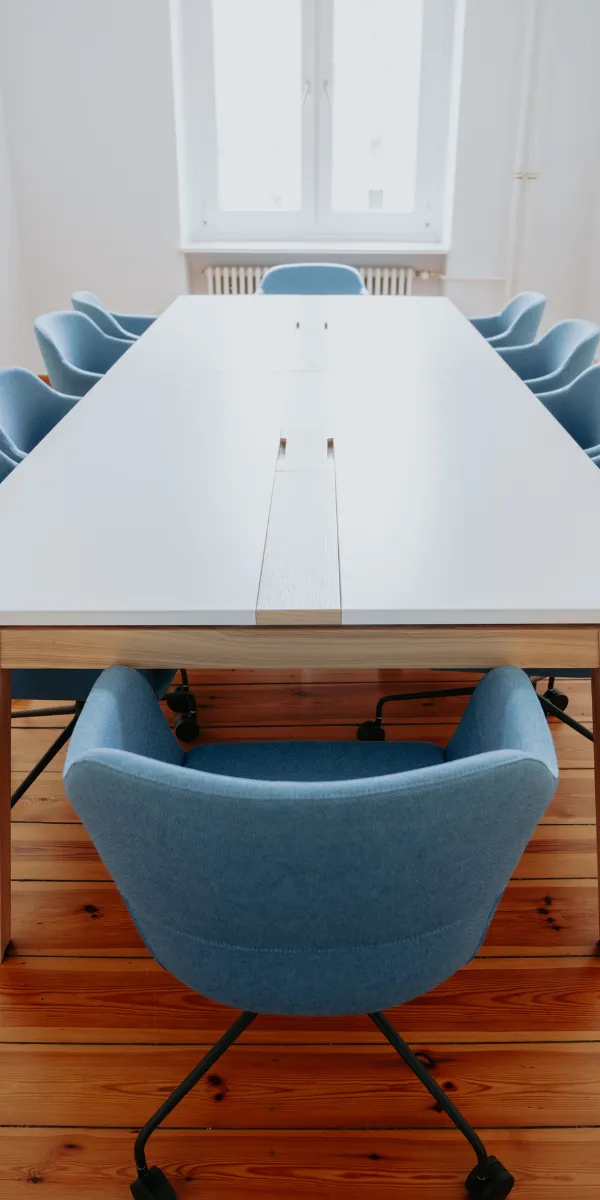 Konferenztisch aus Holz mit Stühlen in modernem Meetingraum