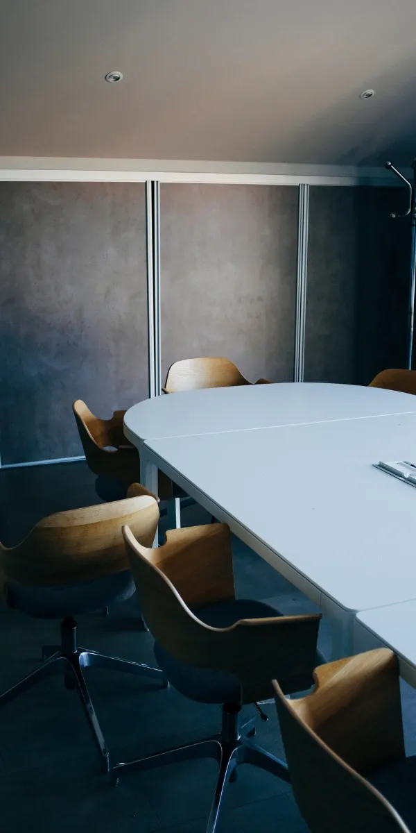 Moderner Konferenztisch mit mehreren Stühlen im Meetingraum