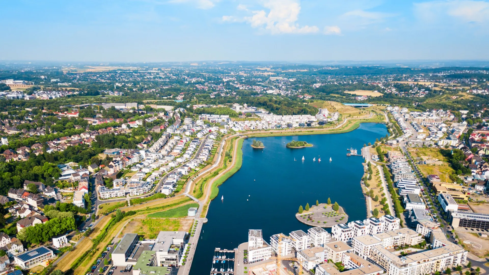 Luftaufnahme eines modernen Stadtteils mit See, kleinen Inseln und Segelbooten in Dortmund, Deutschland.