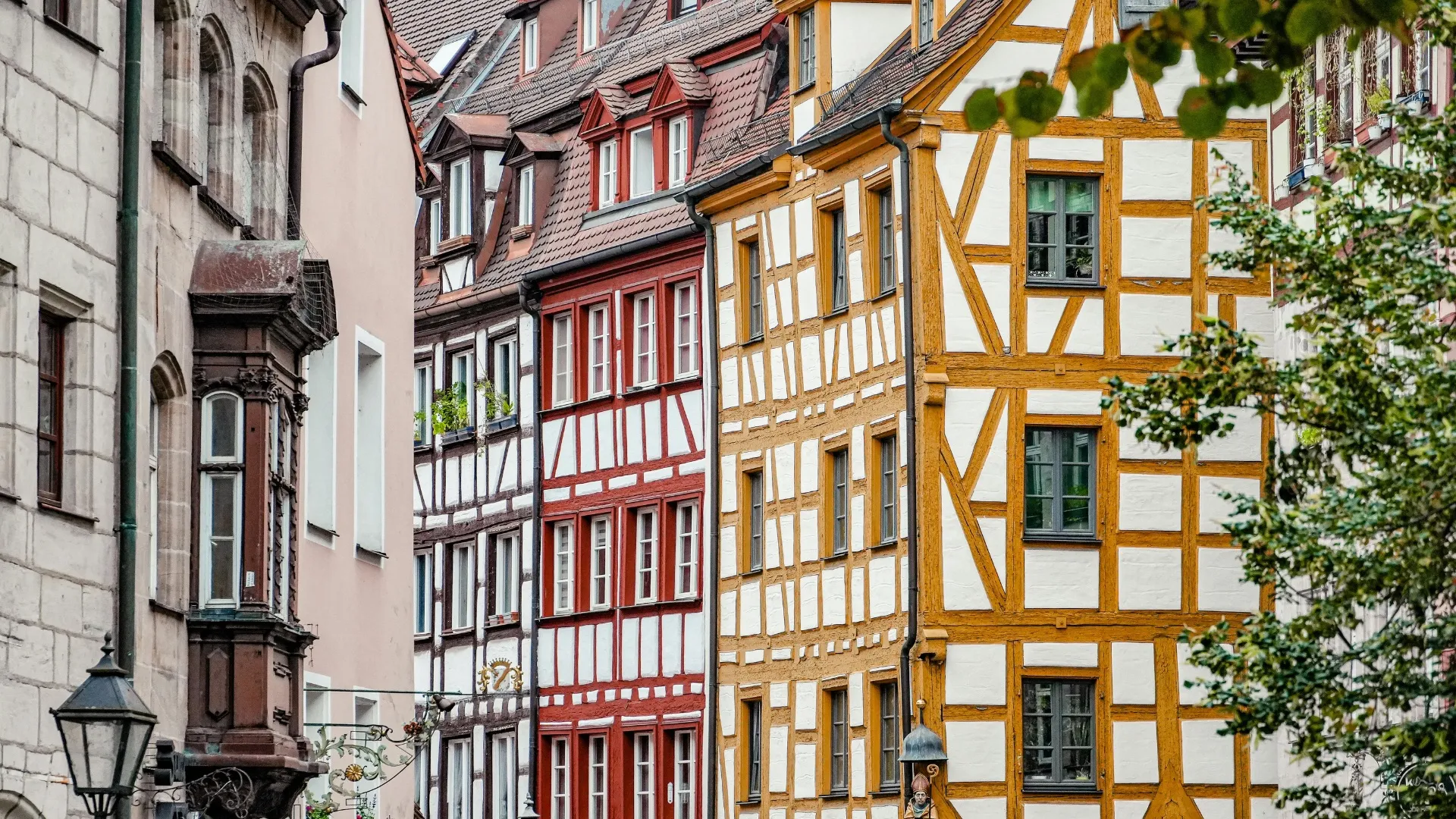 Fachwerkhäuser in Nürnberg mit weißen Wänden, roten und gelben Holzbalken und traditionellen Fenstern.