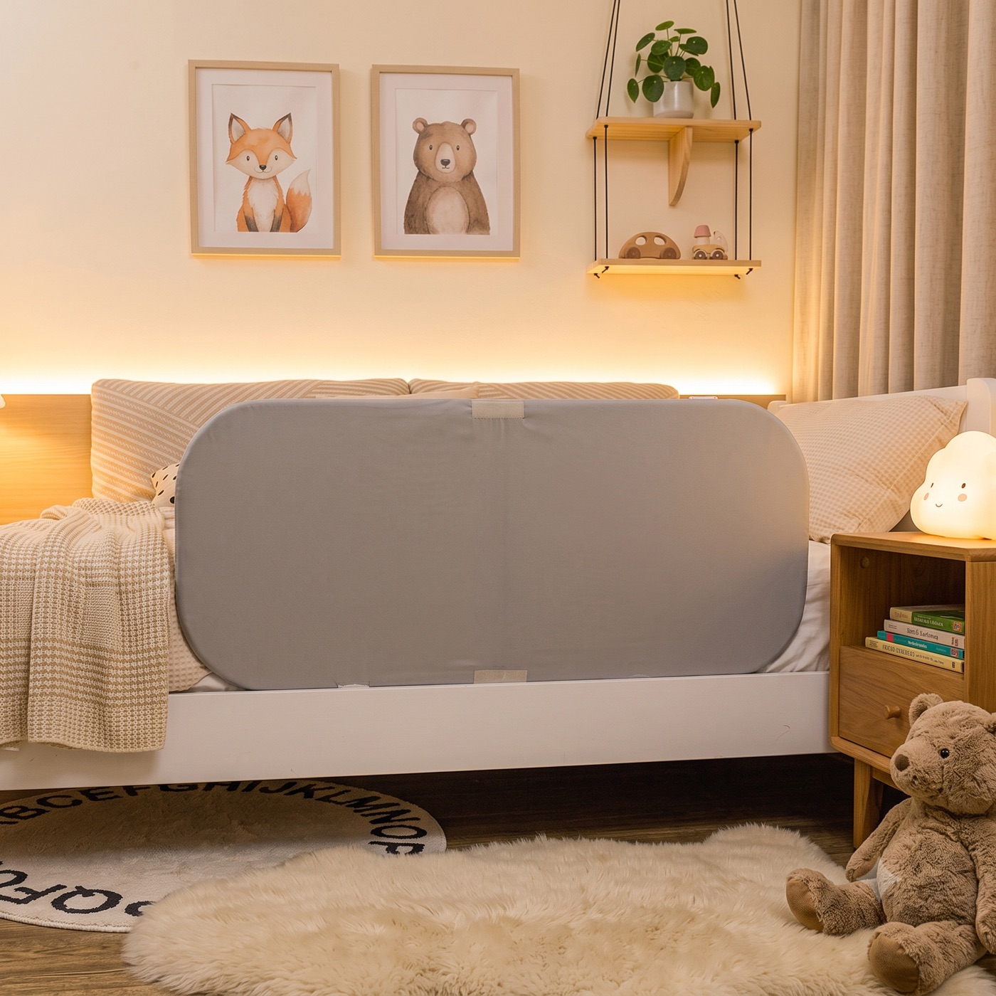 Warm beleuchtetes Kinderzimmer am Abend, das DRITA® Bettgitter am großen Bett, daneben ein Wolken-Nachtlicht