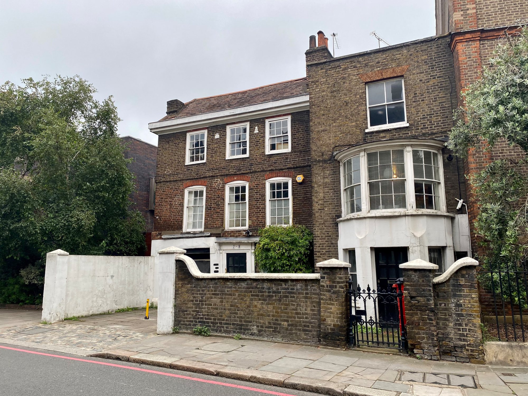 Black front door and chequered steps on a white stucco house