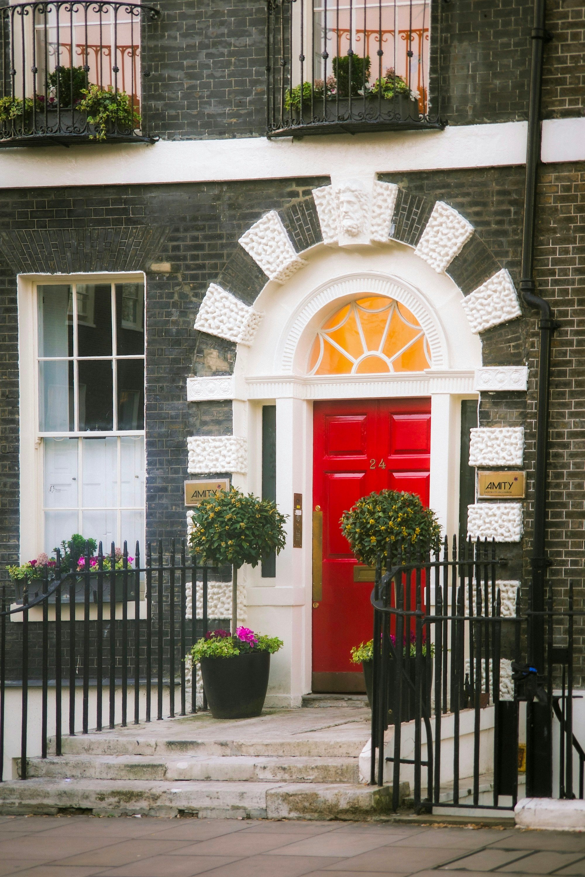 Black front door and chequered steps on a white stucco house