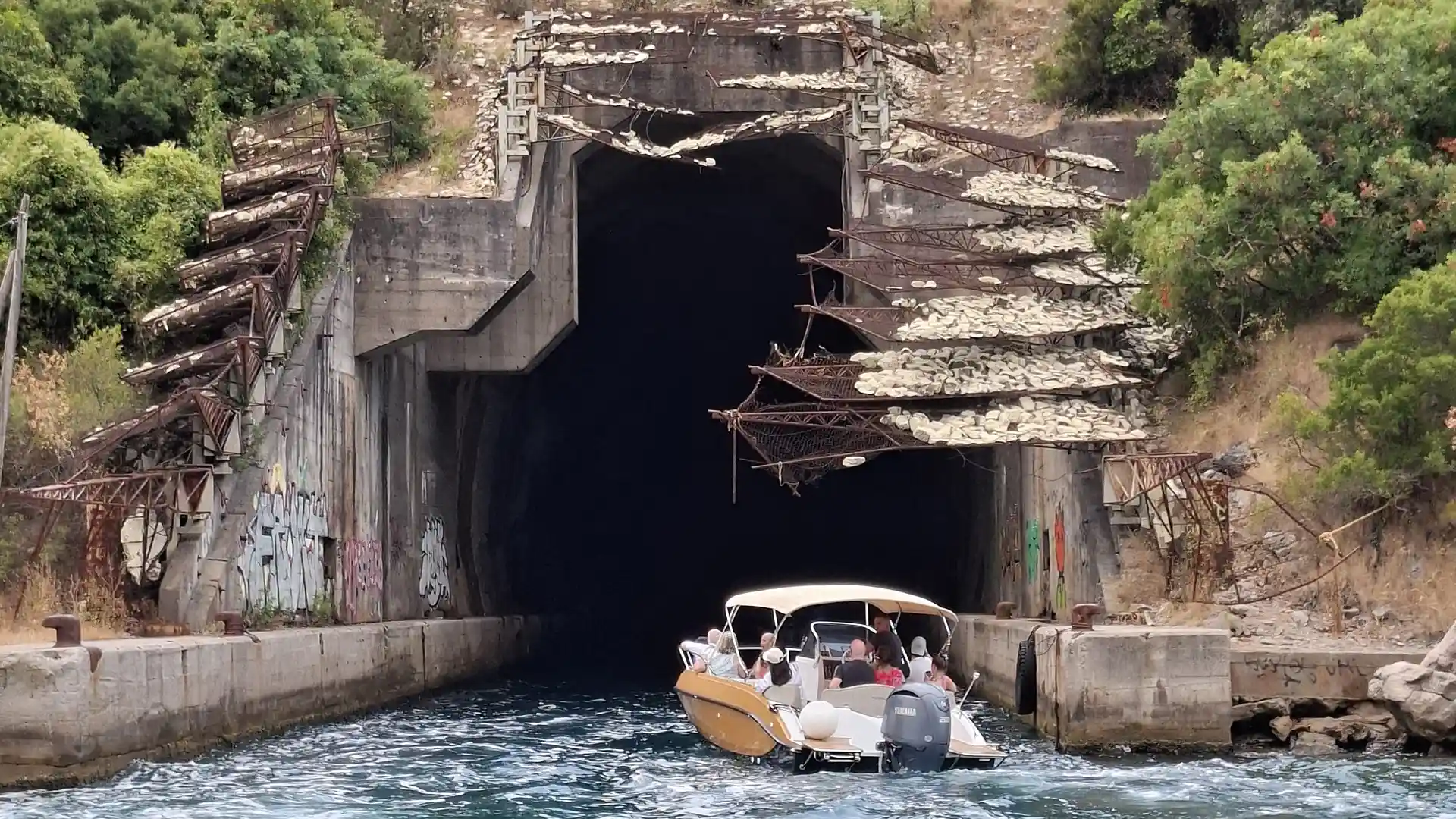 Submarine tunnels entrance along the Boka Bay coastline surrounded by green cliffs in Montenegro