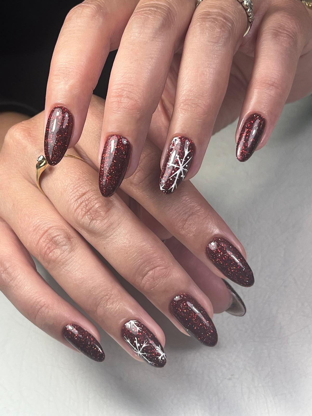 Hand met vier vingers met lichtroze glanzende nagellak en subtiele glitters op de nagelriemen.