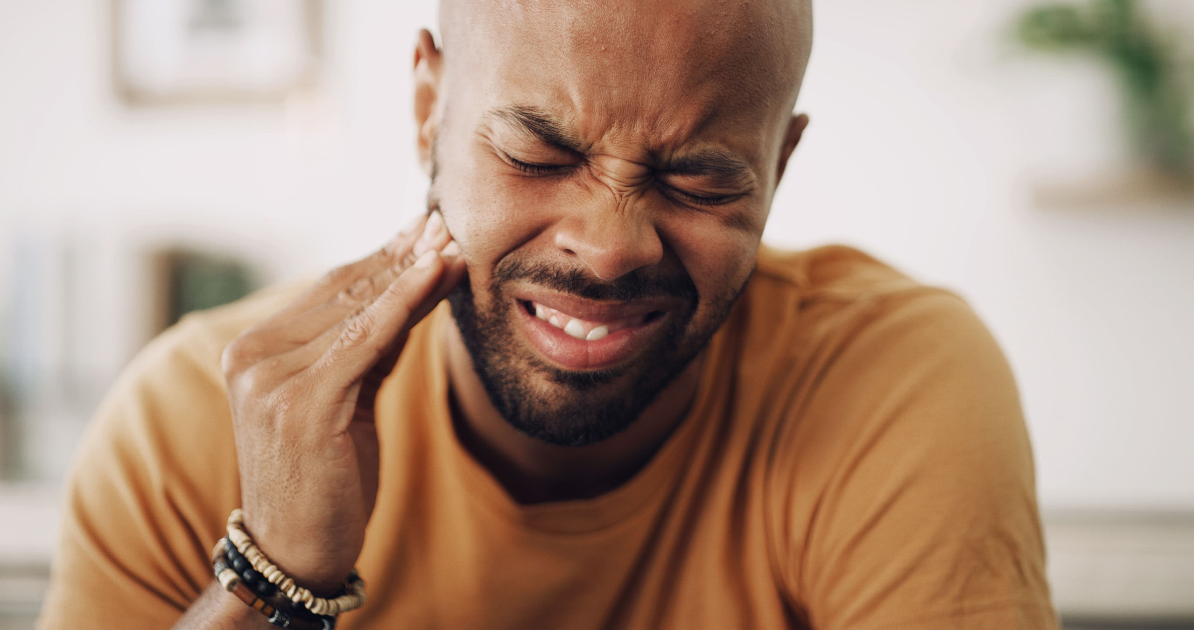 Patient holding his jaw because of wisdom tooth pain