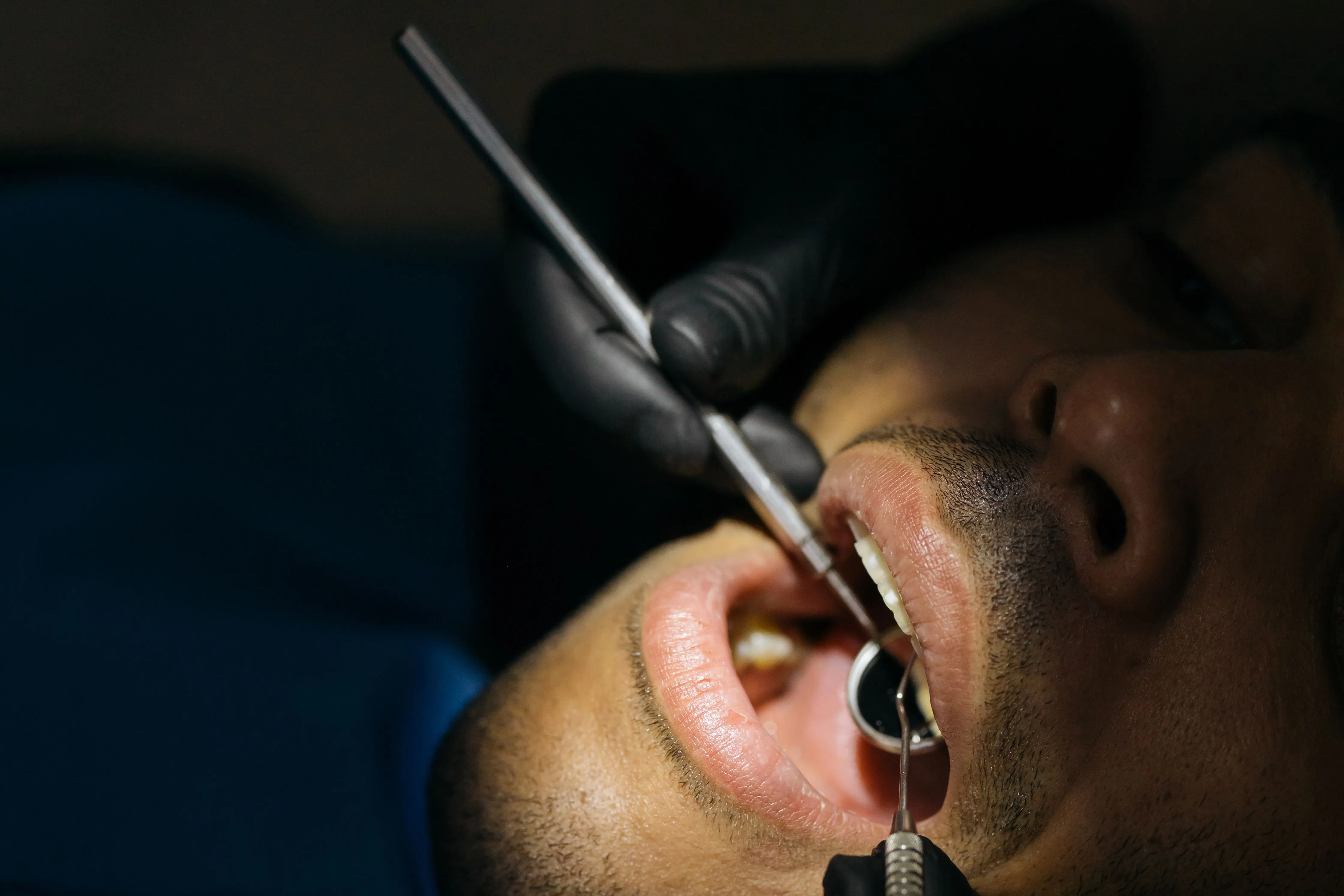 Dentist examining a patient's mouth with dental instruments