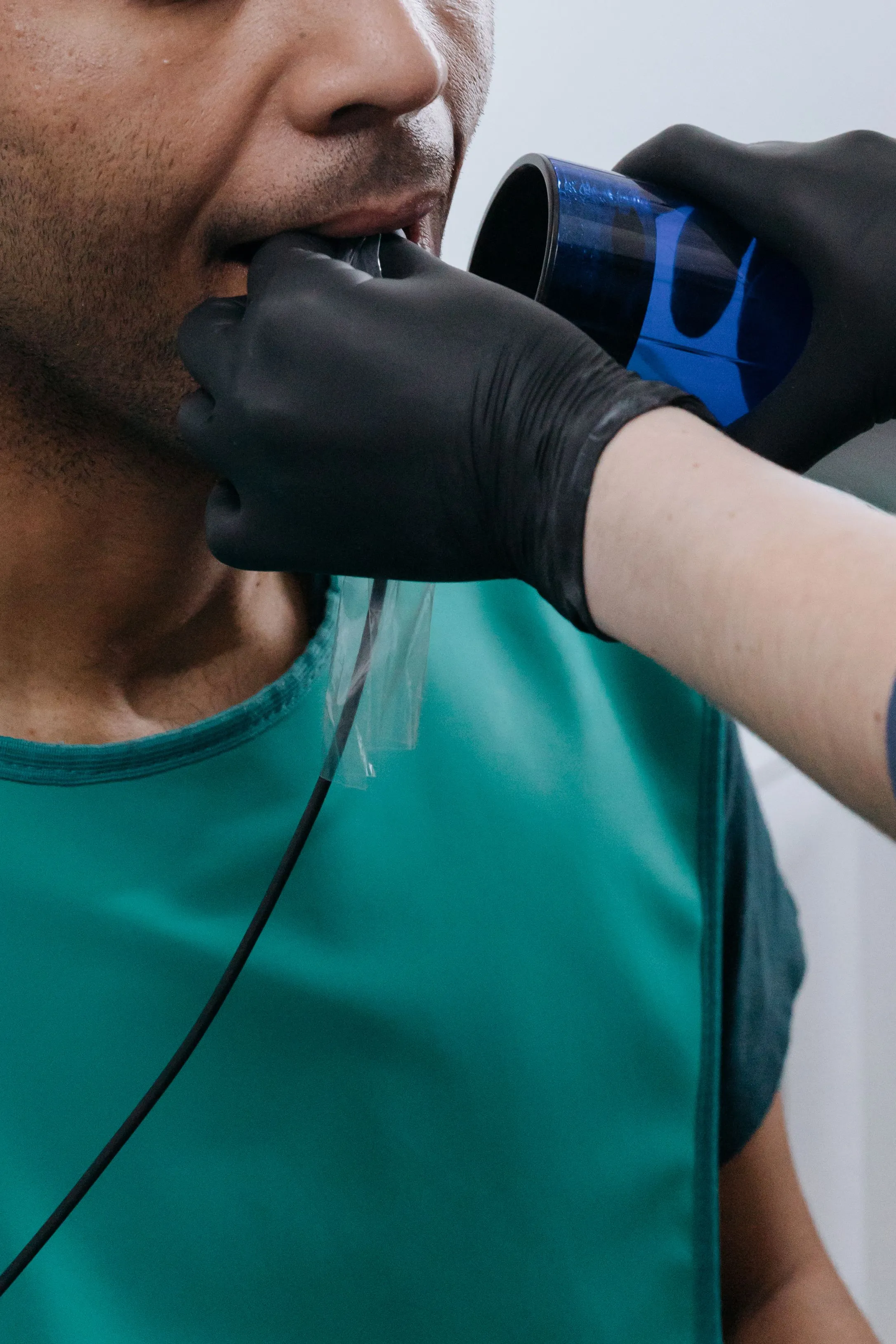 Clinician examining oral tissues with an inspection light