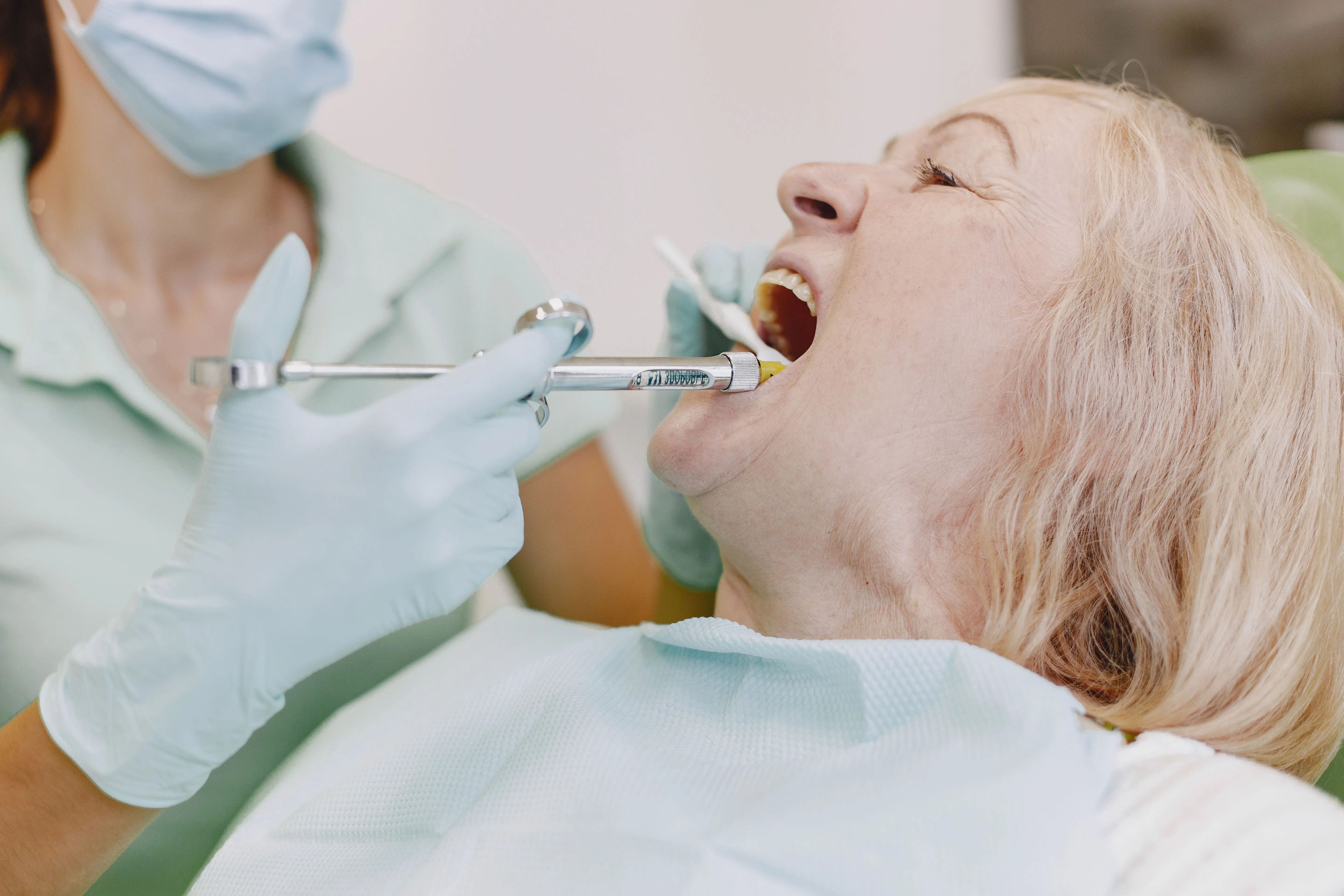 Dentist performing an oral tissue examination