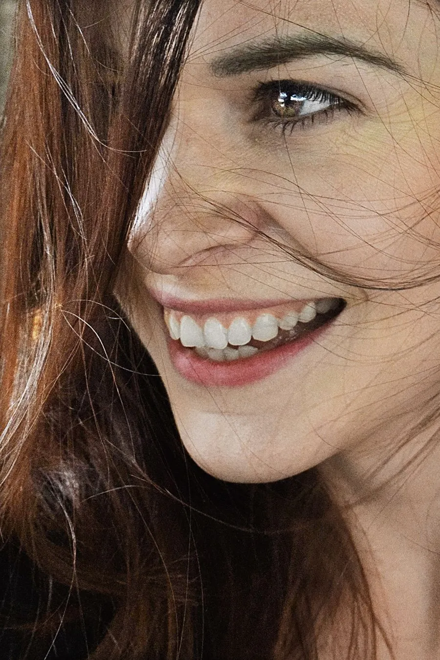 Woman laughing with a natural, bright smile after teeth whitening