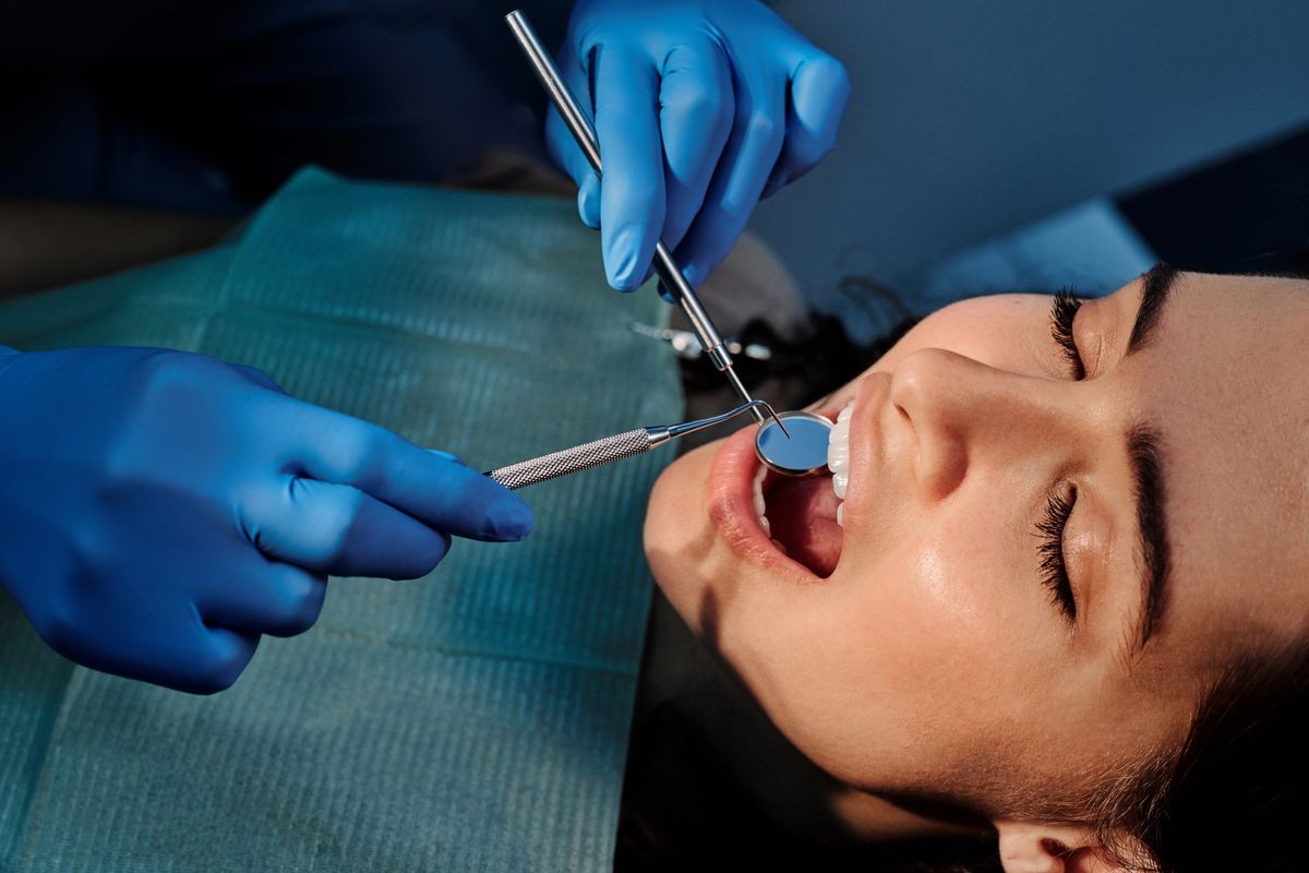 Dentist using a mouth mirror to examine the roof of a patient's mouth