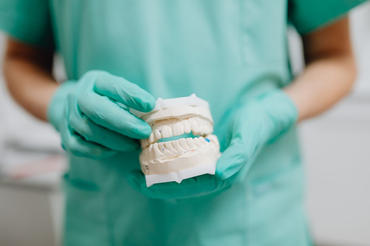 Dental professional holding a dental cast used to plan an upper denture