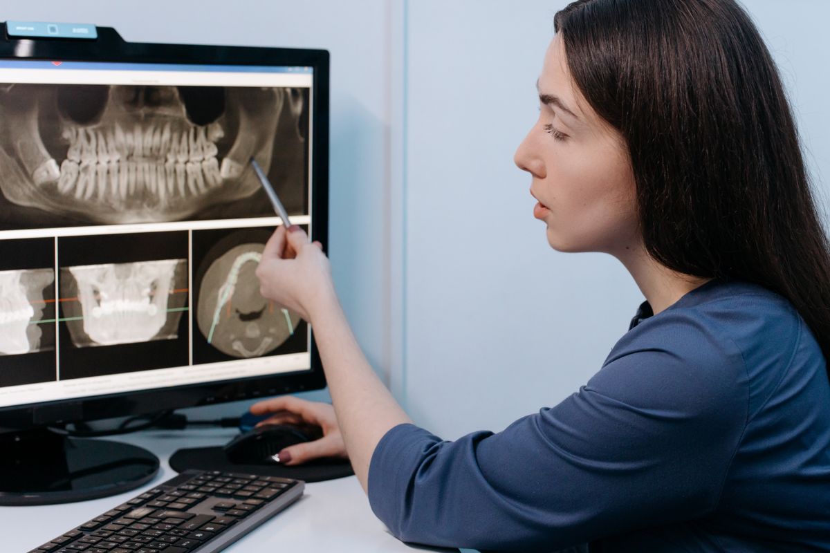 Dentist reviewing 3D dental scans on a monitor to locate an extra tooth