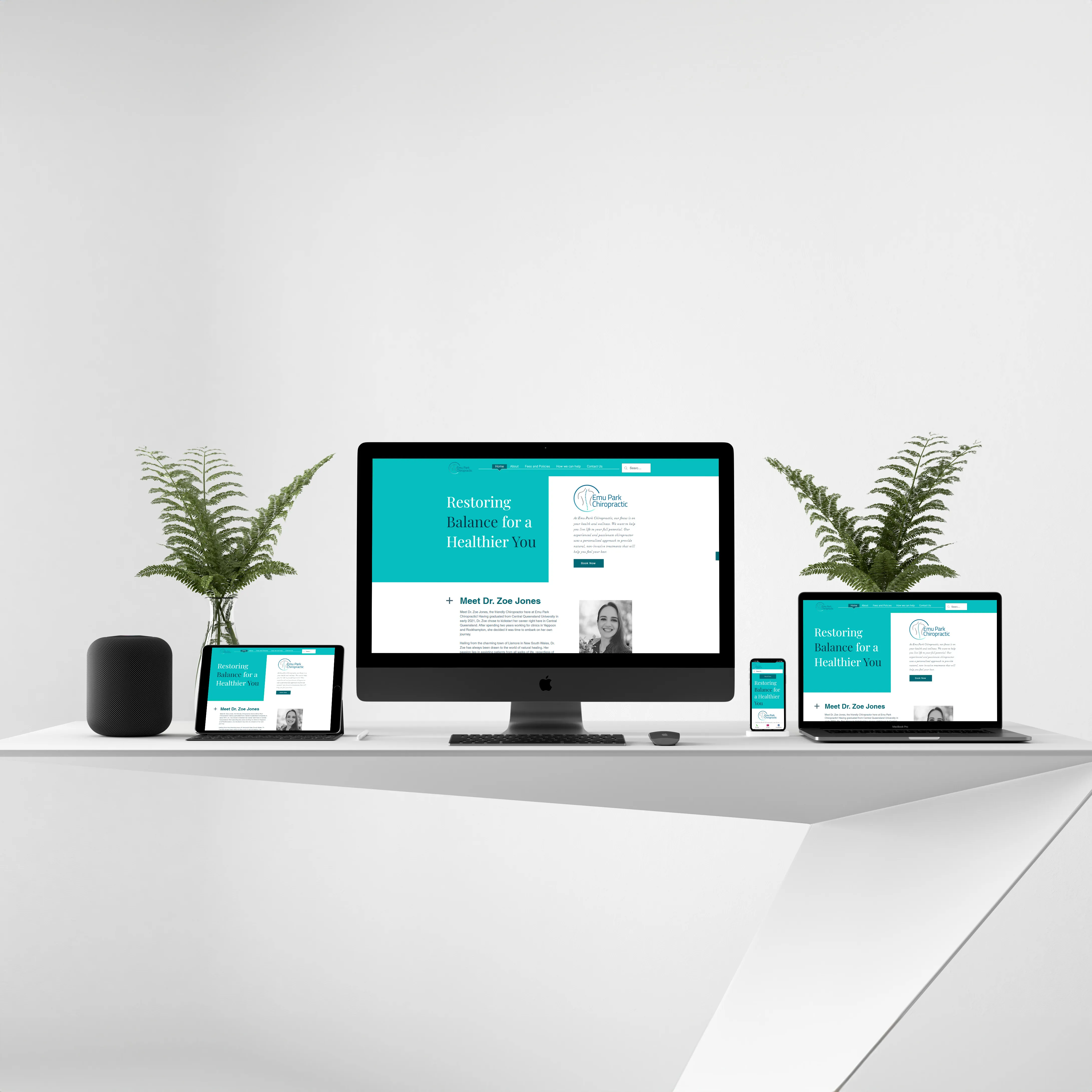 Desktop, laptop, tablet, and smartphone on a white desk displaying the Emu Park Chiropractic website.