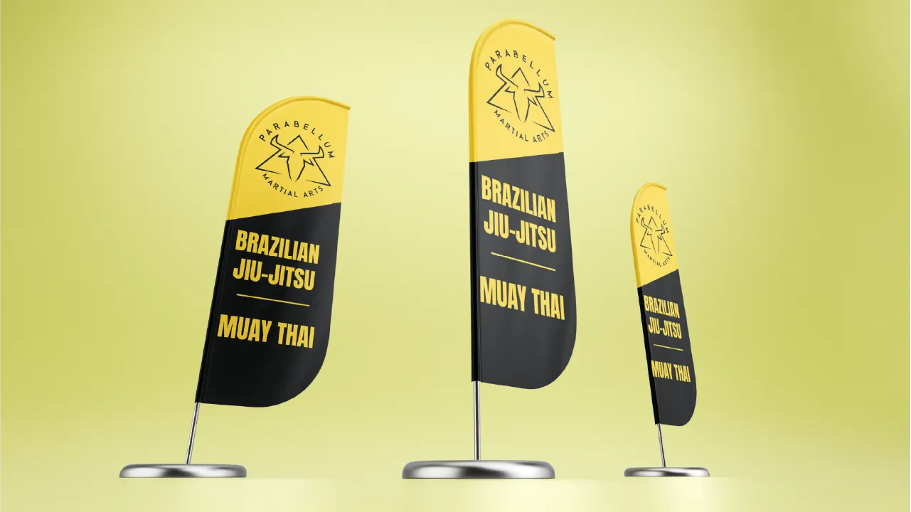Three yellow and black standing flags with Parabellum Martial Arts logo and text Brazilian Jiu-Jitsu Muay Thai.