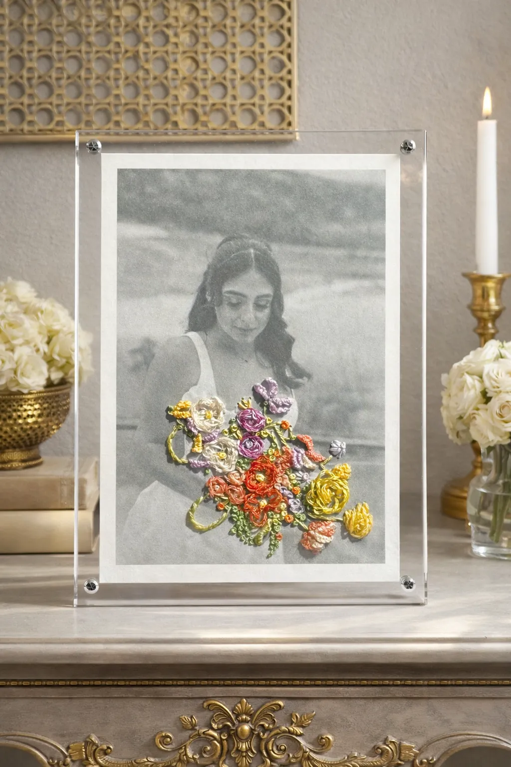 Black and white wedding photo with hand-embroidered colorful bouquet stitched directly onto the print, displayed in a clear acrylic frame
