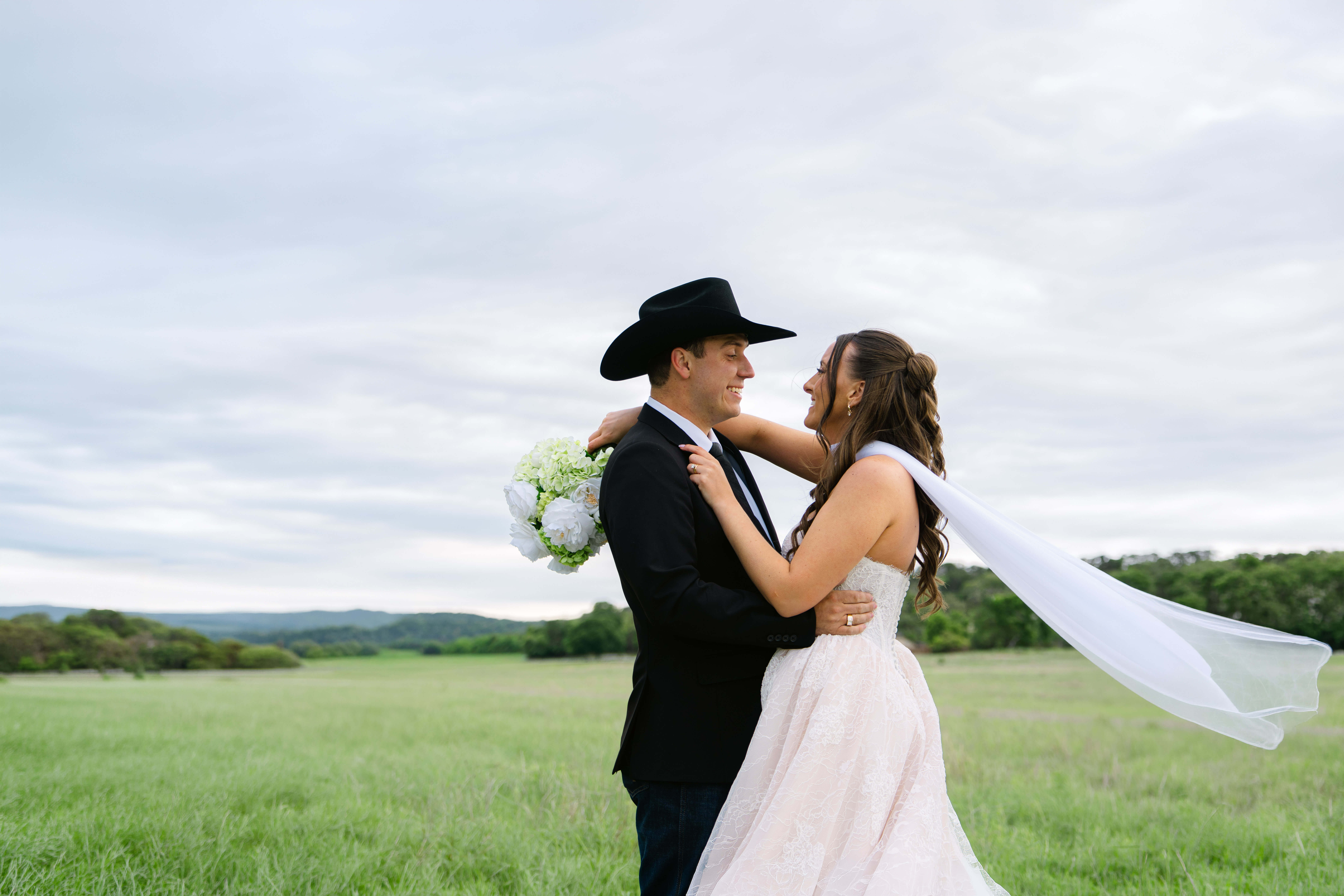 Bride and groom sharing a joyful moment outdoors in the Texas Hill Country, photographed by Austin Texas wedding photographer Moments by Marcela