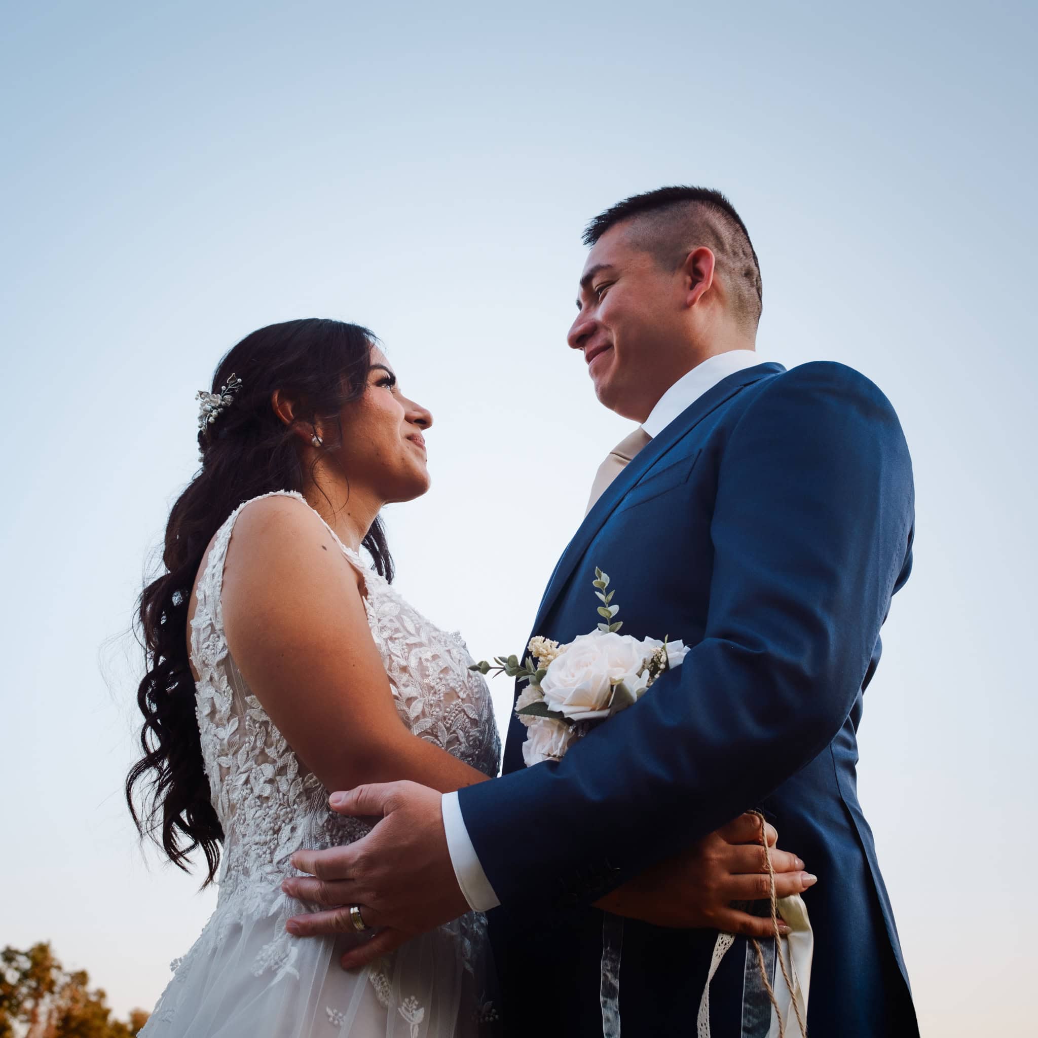 Austin Texas wedding photographer candid moment of two brides laughing under string lights at night one wearing a pink sari