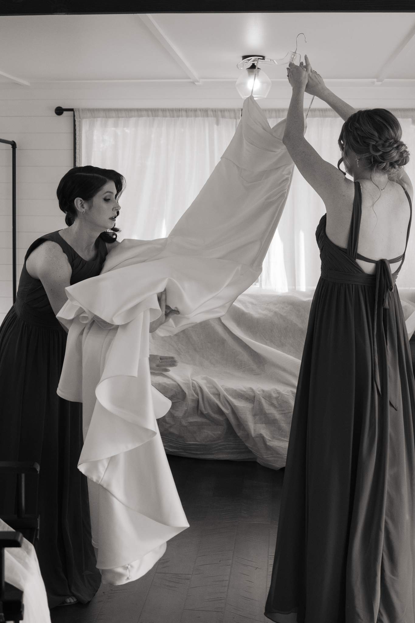 Bridesmaids hanging wedding dress during getting ready – Austin wedding photographer Moments by Marcela