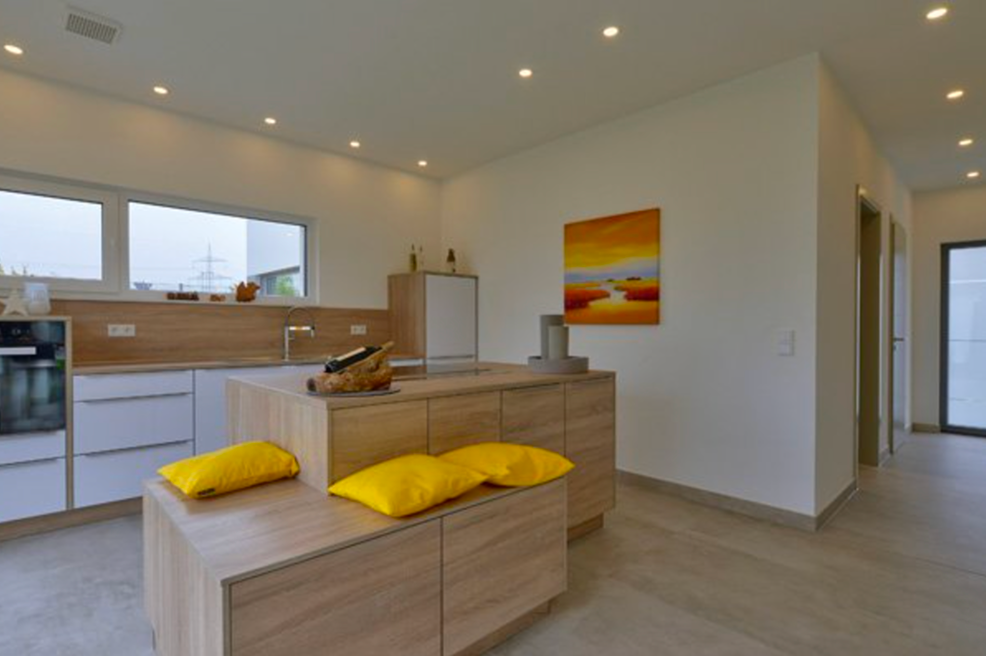 Bungalow mit Flachdach Innenansicht moderne Küche mit Kochinsel und heller Holzoptik