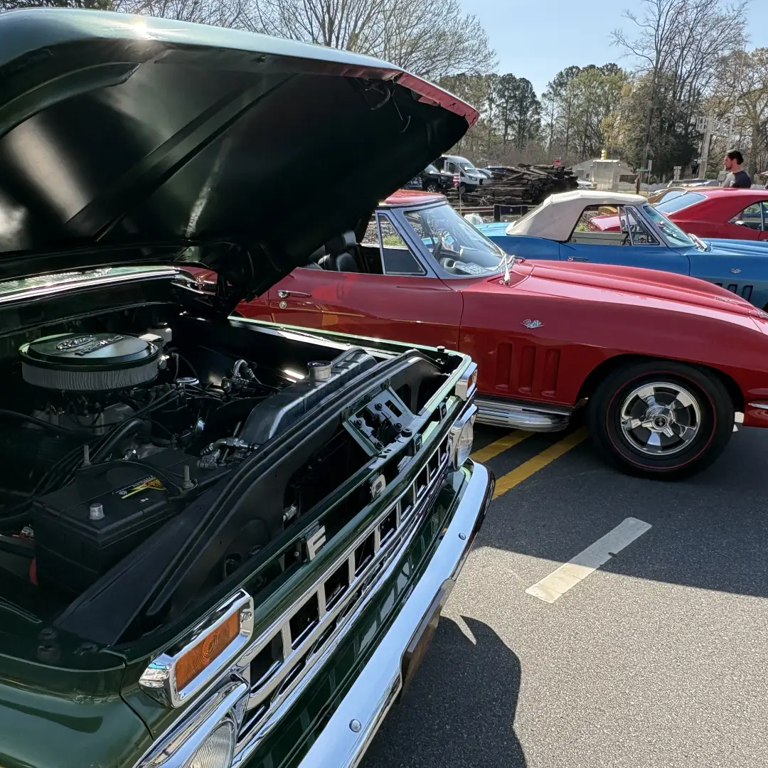 Classic cars and engines on display at a Huntersville car show representing local automotive services