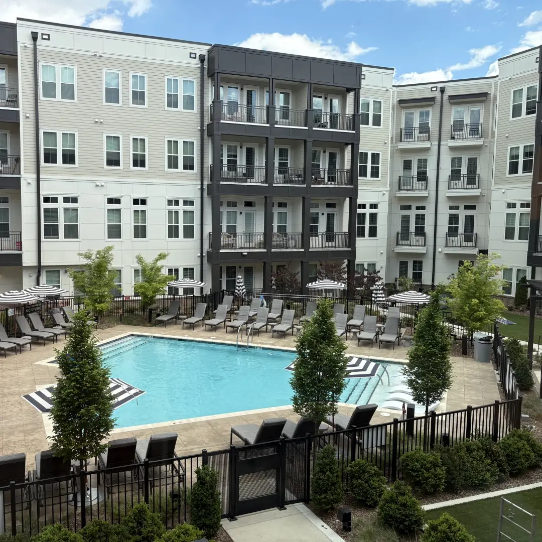 An apartment complex overlooking a community pool representing the category of Housing & Living