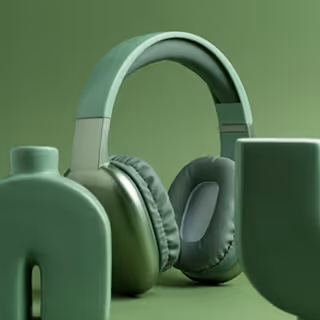 Green over-ear headphones placed between large green sculptural letters on a green background.