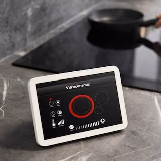 Digital control panel for a vitroceramic stove with power and function buttons on a kitchen countertop.