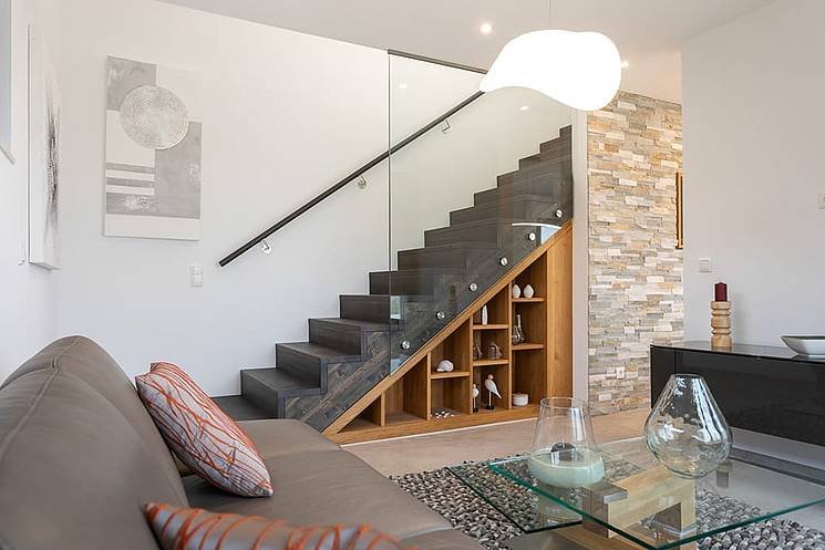 Einfamilienhaus mit Flachdach - modernes Wohnzimmer mit offener Treppe und Glasgeländer