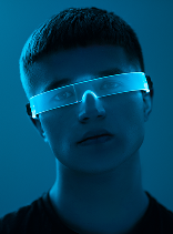 Portrait of a person wearing futuristic glowing blue visor glasses in a dark setting.
