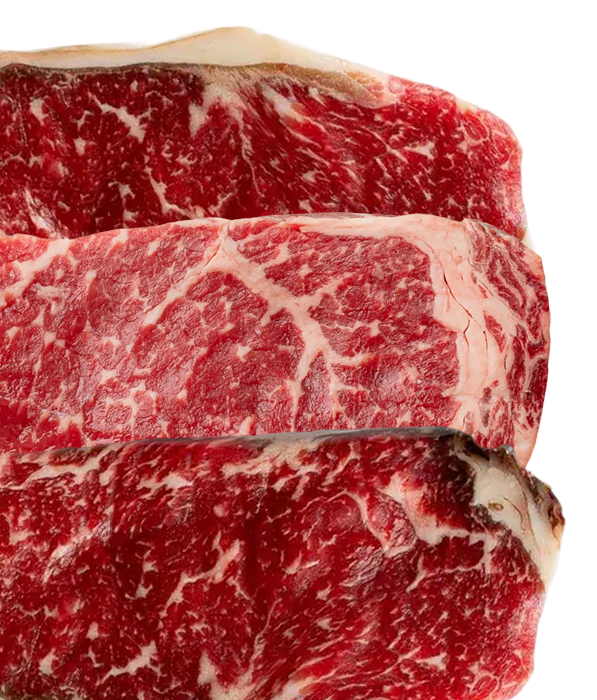 Three raw steaks with marbled fat stacked vertically on a white background.