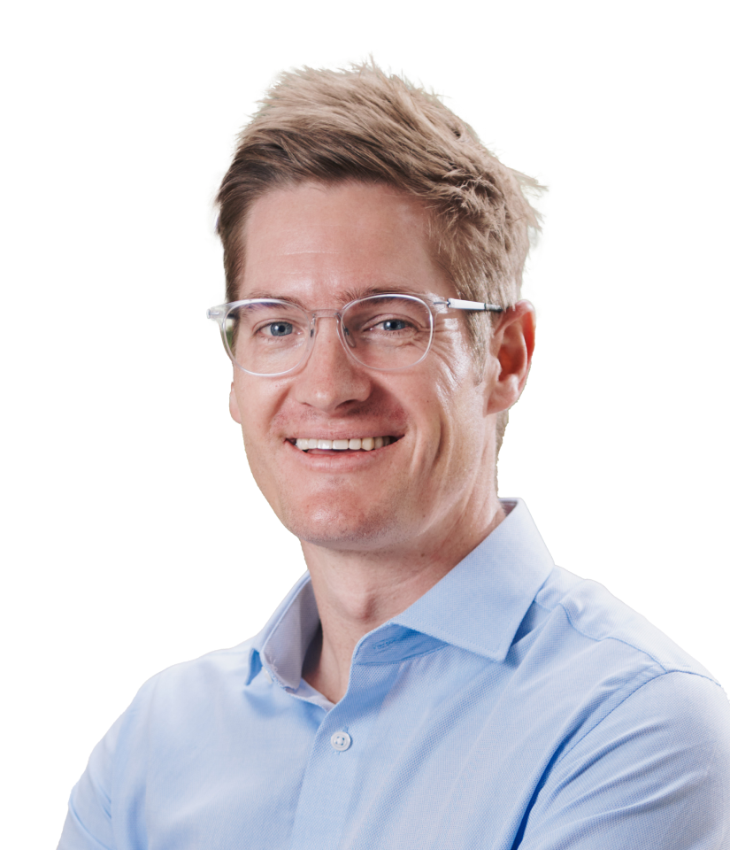 Iwan Swiegers is posed smiling. He has clear framed glasses and is wearing a light blue dress shirt.